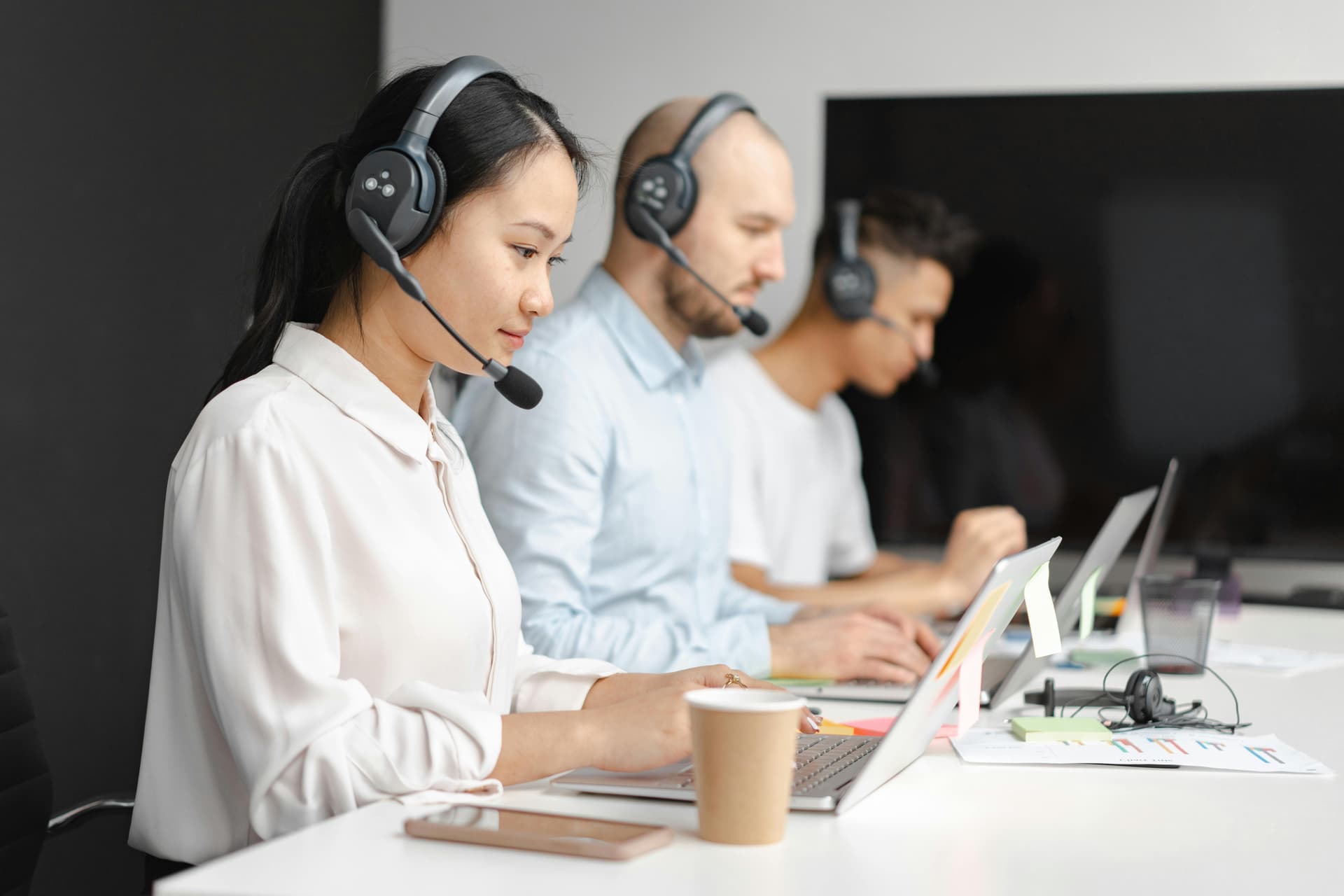 Row of call center agents representing different outsourcing delivery models